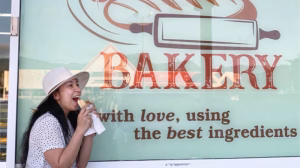 Customer enjoying banh mi at VG Bakery Cairns with scenic local view.